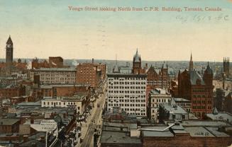 Colour postcard depicting a raised view of a city with many buildings, towers, and a main stree…