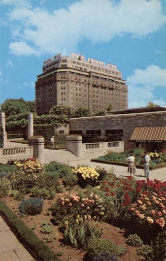 Color photograph of an urban garden in front of a very large hotel complex.