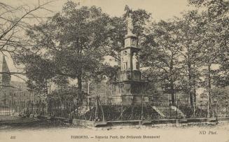 Picture of a large monument with several figures surrounded by trees. 