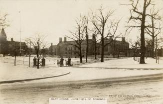 Black and white photograph of a large, gothic style collegiate building with a central tower. S ...