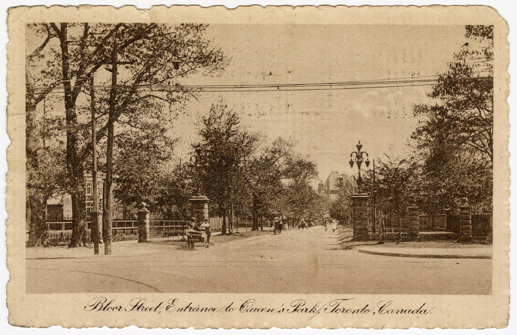 Black and white photograph of an open road running through an iron rail fence. In the backgroun ...