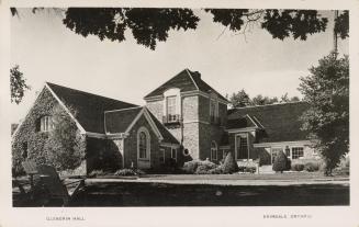 Black and white photograph of a large building with gabled roofs.